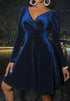 Woman wearing a deep blue velvet long sleeve fit-and-flare mini dress with V-neckline