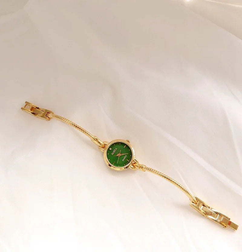 Gold bracelet watch with green dial, slim chain band, elegant minimalist jewelry style
