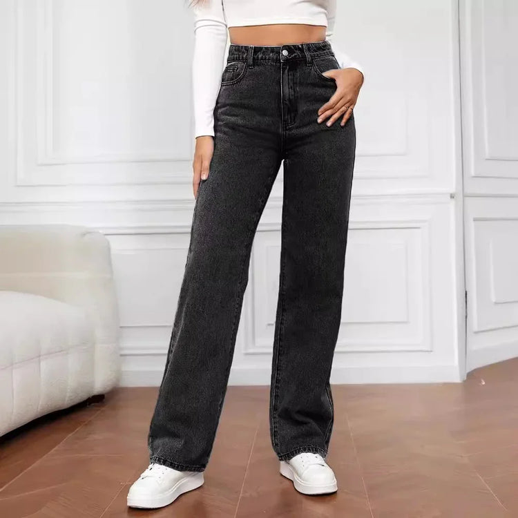 Woman wearing high-waisted black wide-leg jeans, white crop top, and sneakers indoors.