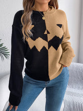 Colorblock black and beige knit sweater with pumpkin face design, relaxed fit, paired with jeans