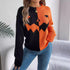 Color block orange and black pumpkin face sweater, relaxed fit, paired with blue jeans.