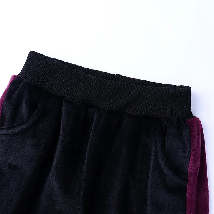 Black velvet joggers with ribbed waistband and purple side panels, relaxed fit streetwear