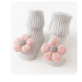 Gray ribbed baby socks with soft pink flower appliqué, cozy cotton knit, ankle length.