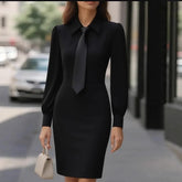 Woman wearing a fitted black long-sleeve dress with a necktie, chic urban streetwear style