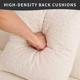 Hand pressing into a plush, textured white high-density back cushion to show softness.