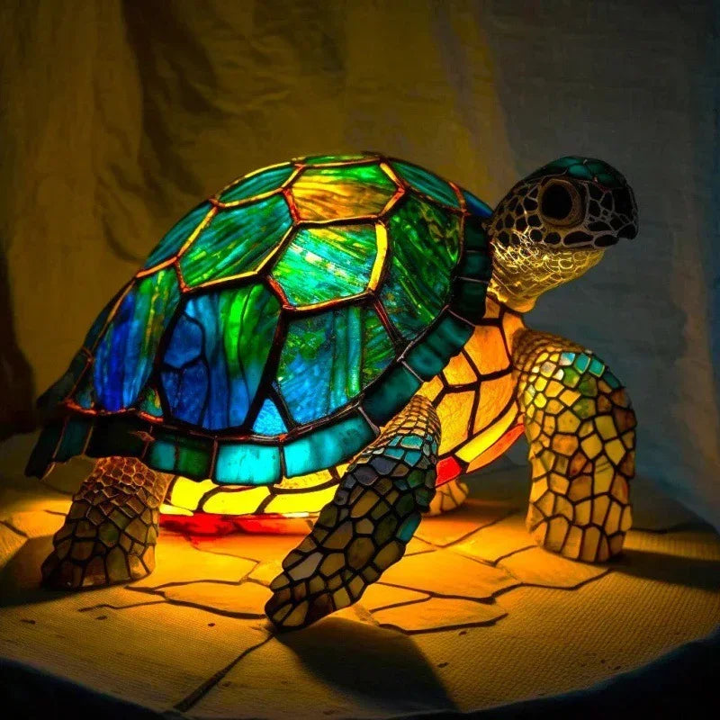 Stained glass turtle lamp with vibrant blue, green, and yellow shell, glowing on tabletop