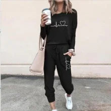 Woman in black streetwear lounge set with heart graphic, relaxed fit joggers, and white sneakers