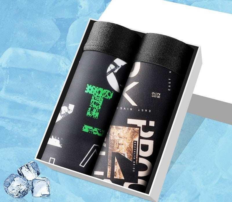 Two rolled black graphic streetwear t-shirts with bold prints in a gift box, modern style