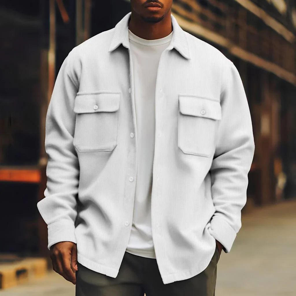Man wearing a white oversized button-up shirt jacket with front flap pockets, casual fit