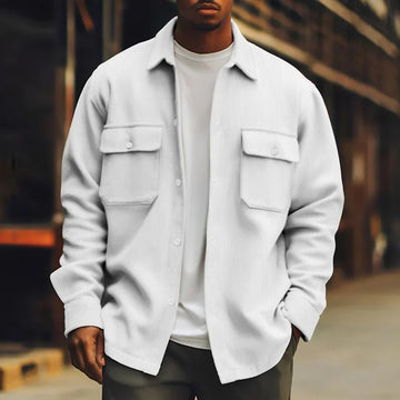 Man wearing a white oversized button-up shirt jacket with front flap pockets, casual fit