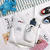 White canvas tote bag with front pockets, adjustable strap, casual streetwear style