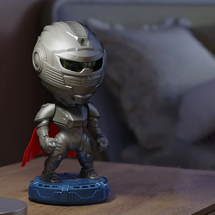 Futuristic silver armored figure with a red cape standing on a blue base