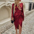 Woman wearing a red velvet wrap dress with long sleeves and side tie, slim fit