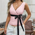 Sleeveless pink lace wrap top with black ribbon belt, v-neck, fitted silhouette