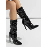 Shiny black patent leather stiletto heeled boots with pointed toe and slouchy fit