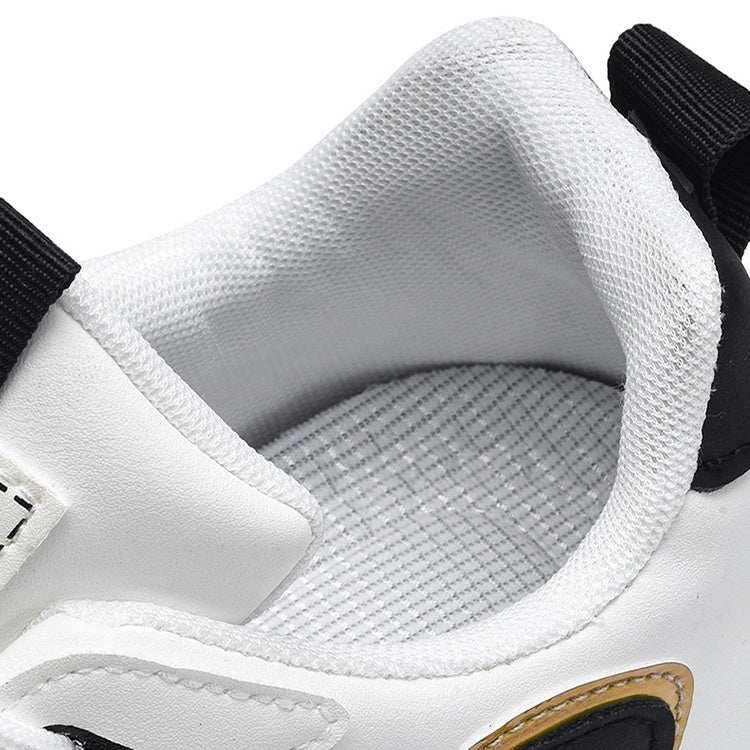 Close-up of white mesh athletic sneaker with cushioned collar and black accents