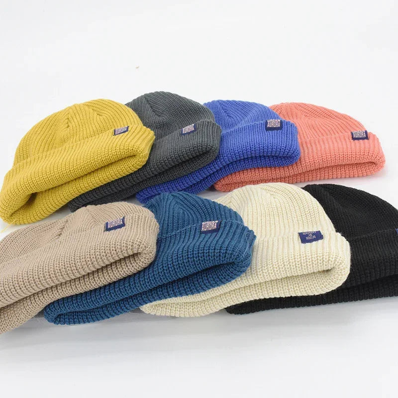 Assorted ribbed knit beanies in yellow, gray, blue, coral, beige, teal, cream, and black colors.