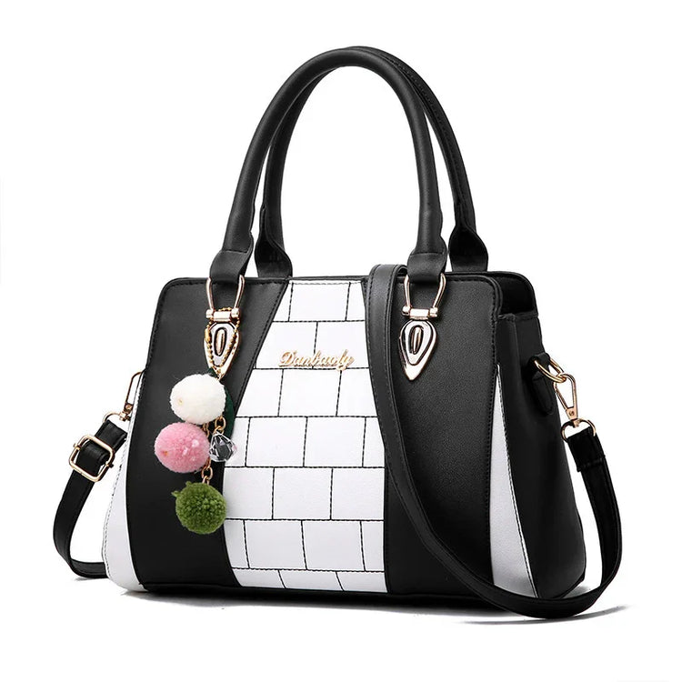 Black and white colorblock handbag with geometric pattern, faux leather, structured fit, pom pom keychain