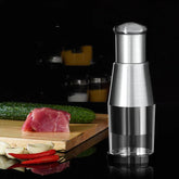 Stainless steel manual food chopper on black counter with cucumber, meat, garlic, and chili