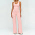 Woman wearing light pink fitted tank top and wide-leg pants, stretchy activewear set