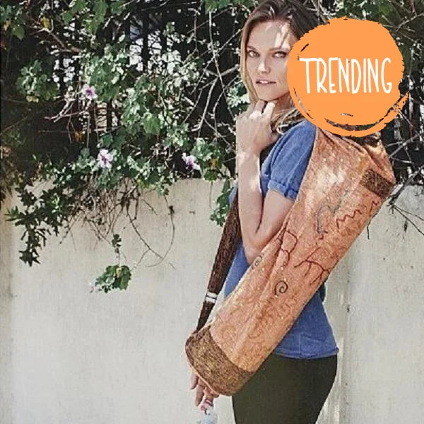 Woman carrying handcrafted OM Sutra yoga bag with embroidered cotton fabric and bohemian design outdoors