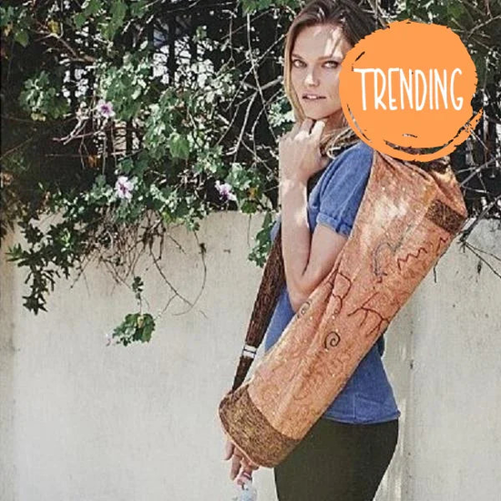 Woman carrying handcrafted OM Sutra yoga bag with embroidered cotton fabric and bohemian design outdoors