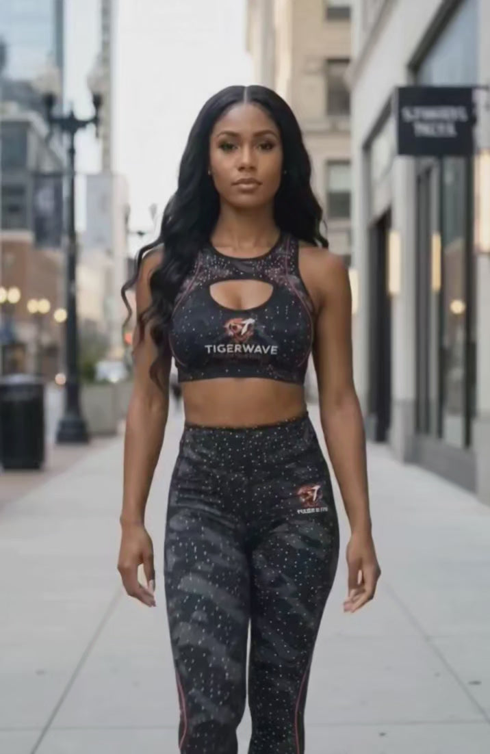 Model wearing black tiger stripe activewear set with sports bra and high-waisted leggings, walking on city sidewalk outdoors