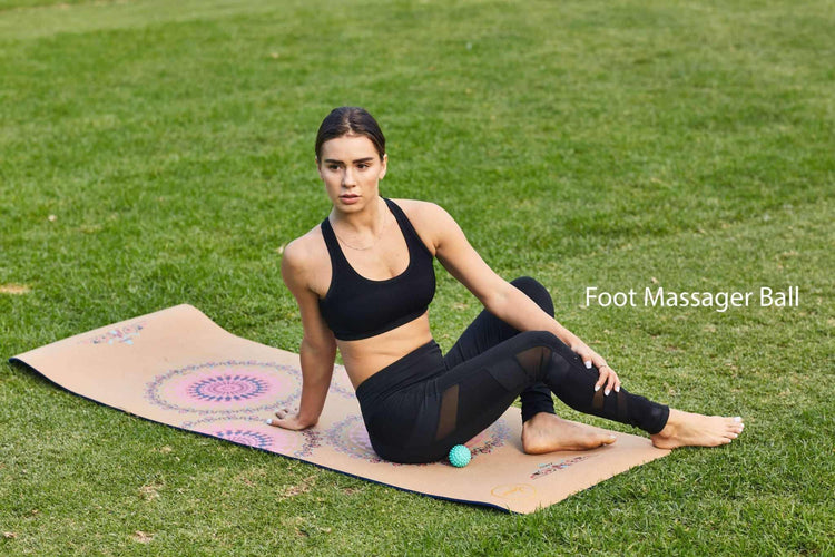 Woman in black sports bra and mesh panel leggings, sitting on yoga mat outdoors